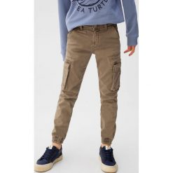 Mango Kids - Spodnie dziecięce Salva 110-164 cm. Pomarańczowe spodnie chłopięce Mango Kids, bez wzorów, z elastanu, casualowe. Za 99,90 zł.