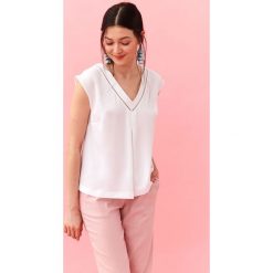 Elegancka bluzka z ozdobnym dekoltem. Białe bluzki damskie Top Secret, z haftami, eleganckie, z dekoltem w serek, bez rękawów. W wyprzedaży za 39,99 zł.