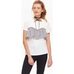 T-shirt damski z ciekawą aplikacją w kratę wiązaną z tyłu. Białe t-shirty damskie TROLL, s, z aplikacjami, z bawełny, z kontrastowym kołnierzykiem. W wyprzedaży za 19,99 zł.