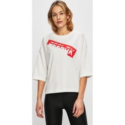 Reebok - Top. Białe topy damskie Reebok, s, z nadrukiem, z elastanu, z okrągłym kołnierzem. W wyprzedaży za 89,90 zł.