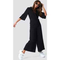NA-KD Trend Krótki kombinezon z paskiem - Black. Czarne kombinezony damskie NA-KD Trend, z poliesteru, z krótkim rękawem, krótkie. Za 283,95 zł.