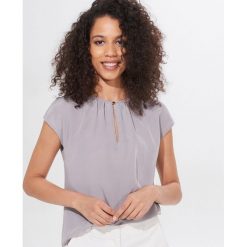Bluzka z ozdobnym zapięciem - Szary. Szare bluzki damskie Mohito, s, bez wzorów, bez kołnierzyka, bez rękawów. Za 59,99 zł.