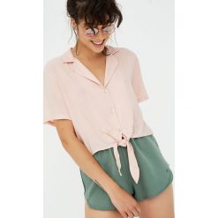Koszula z klapami i węzłem. Różowe koszule damskie marki Pull&Bear, bez wzorów, bez kołnierzyka, z krótkim rękawem. Za 59,90 zł.