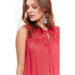Bluzka bez rękawów damska, koronkową aplikacją. Pomarańczowe bluzki damskie Top Secret, z aplikacjami, z tkaniny, eleganckie, bez kołnierzyka, bez rękawów. W wyprzedaży za 54,99 zł.