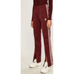 Adidas Originals - Spodnie. Czerwone spodnie damskie adidas Originals, bez wzorów, z poliesteru, casualowe. W wyprzedaży za 199,90 zł.