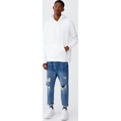 Jeansy relaxed fit z przetarciami. Niebieskie jeansy męskie relaxed fit Pull&Bear. Za 159,00 zł.