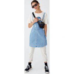 Jeansowa sukienka ogrodniczka z niewykończonym dołem. Szare sukienki damskie Pull&Bear, bez wzorów, z jeansu, bez kołnierzyka, bez rękawów. Za 89,90 zł.