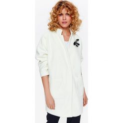Płaszcz damski o nowoczesnym kroju, z odpinaną ozdobą. Białe płaszcze damskie Top Secret, na lato, z aplikacjami, eleganckie. W wyprzedaży za 199,99 zł.