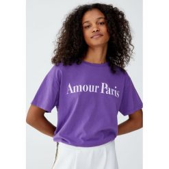 Koszulka z napisem „Amour Paris”. Fioletowe bluzki damskie marki Pull&Bear, z napisami, z krótkim rękawem. Za 49,90 zł.