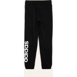 Adidas - Spodnie dziecięce 128-176 cm. Czarne dresy chłopięce Adidas, z nadrukiem, z bawełny. Za 129,90 zł.