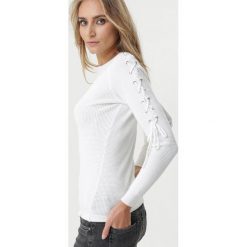 Biały Sweter Seagoville. Białe swetry damskie Born2be, s, bez wzorów, z jeansu, klasyczne, bez rękawów, bez kaptura. Za 79,99 zł.