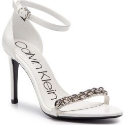 Sandały CALVIN KLEIN - Rajni E8858 White. Białe klapki damskie Calvin Klein, bez wzorów, ze skóry ekologicznej, bez obcasa, na obcasie. W wyprzedaży za 419,00 zł.