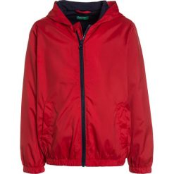 Benetton Kurtka przeciwdeszczowa red. Czerwone kurtki męskie przeciwdeszczowe Benetton, z poliesteru. Za 129,00 zł.