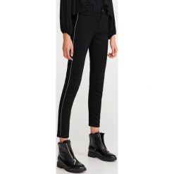 Jeansy slim z lampasami - Czarny. Czarne jeansy damskie Reserved. Za 119,99 zł.