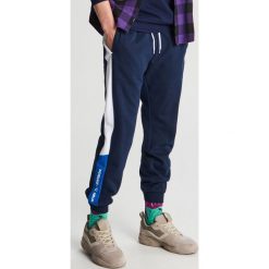 Joggery w sportowym stylu z lampasem - Niebieski. Niebieskie spodnie męskie Cropp, s, bez wzorów, sportowe. Za 99,99 zł.