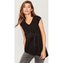 Koszulka z łańcuszkową aplikacją - Czarny. Czarne t-shirty damskie marki Mohito, l, z aplikacjami. W wyprzedaży za 29,99 zł.