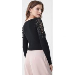 Czarny Sweter Kyla. Czarne swetry dziewczęce Born2be, bez wzorów, z koronki, z okrągłym kołnierzem, z długim rękawem, długie, bez kaptura. Za 79,99 zł.