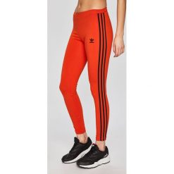 Adidas Originals - Legginsy. Pomarańczowe spodnie damskie adidas Originals, bez wzorów, z elastanu. W wyprzedaży za 89,90 zł.