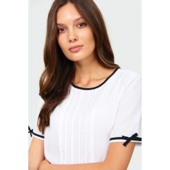 Elegancka bluzka z ozdobnymi taśmami. Bluzki damskie Greenpoint, bez wzorów, z poliesteru, eleganckie, bez kołnierzyka, bez rękawów. Za 79,99 zł.