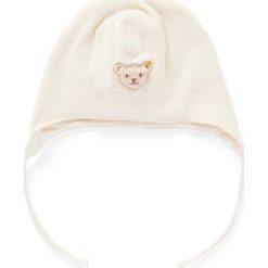 Czapka w kolorze kremowym. Białe czapeczki niemowlęce Steiff, z aplikacjami, z bawełny. W wyprzedaży za 42,95 zł.